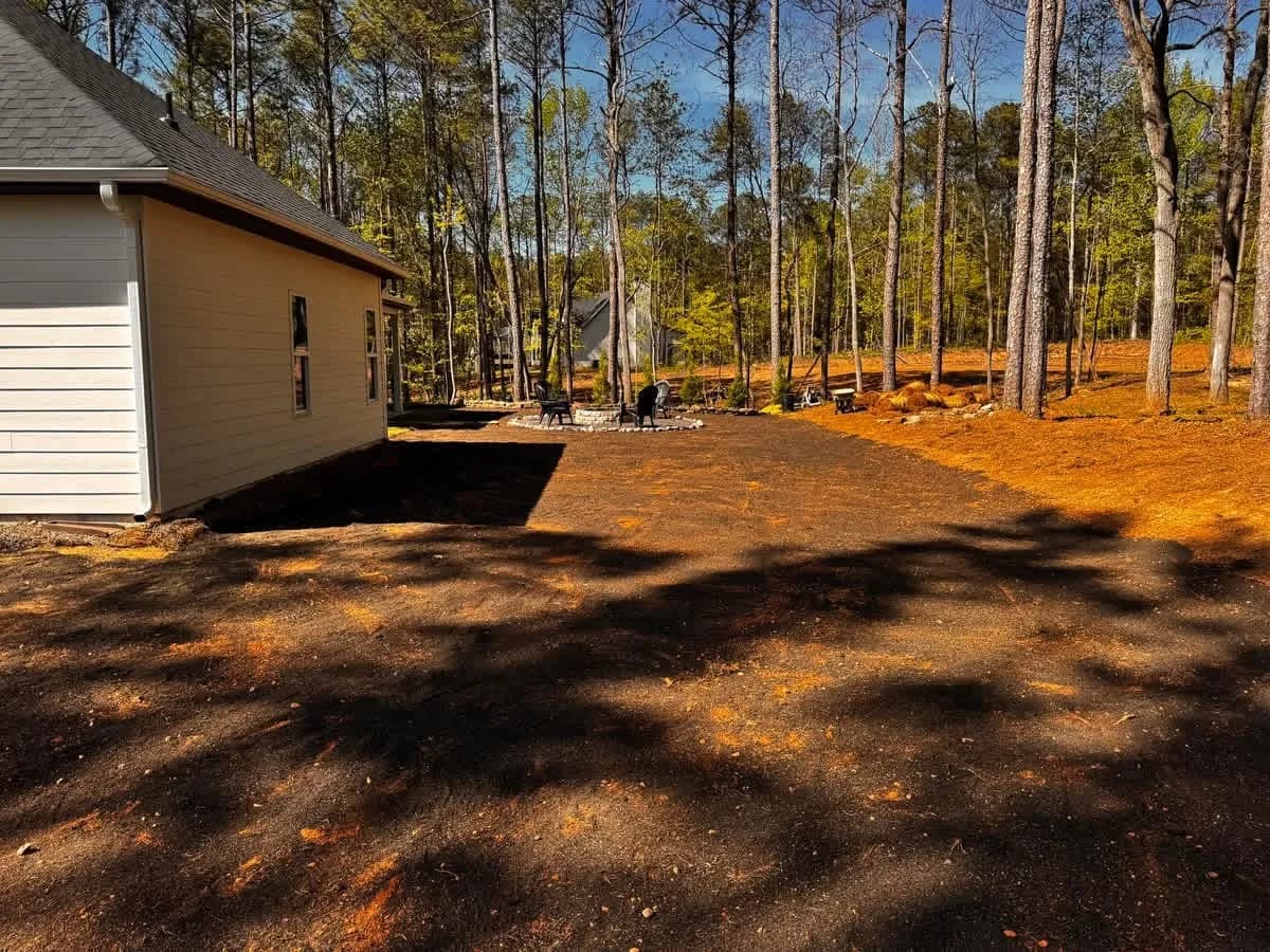 Graded bare dirt beside a new house before sod