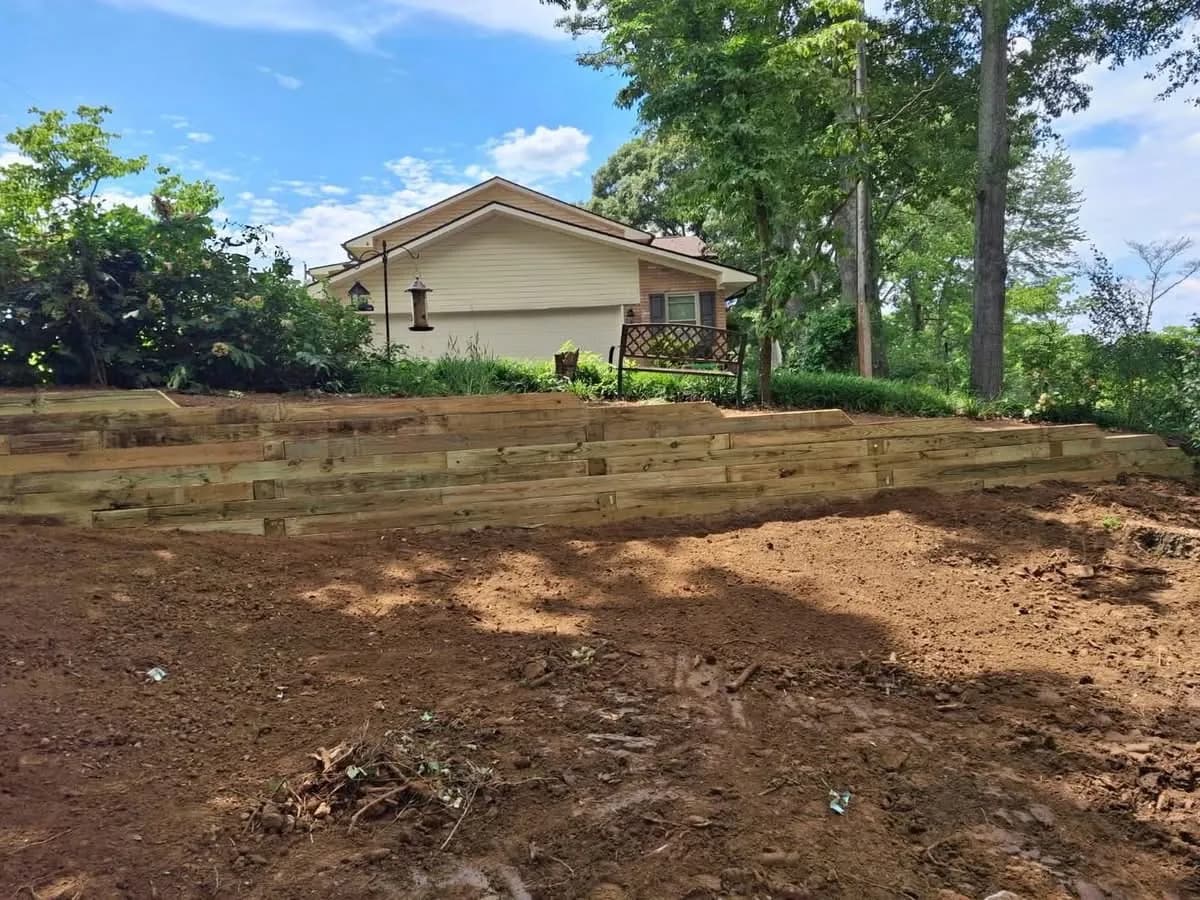 Timber retaining wall under construction on a graded slope